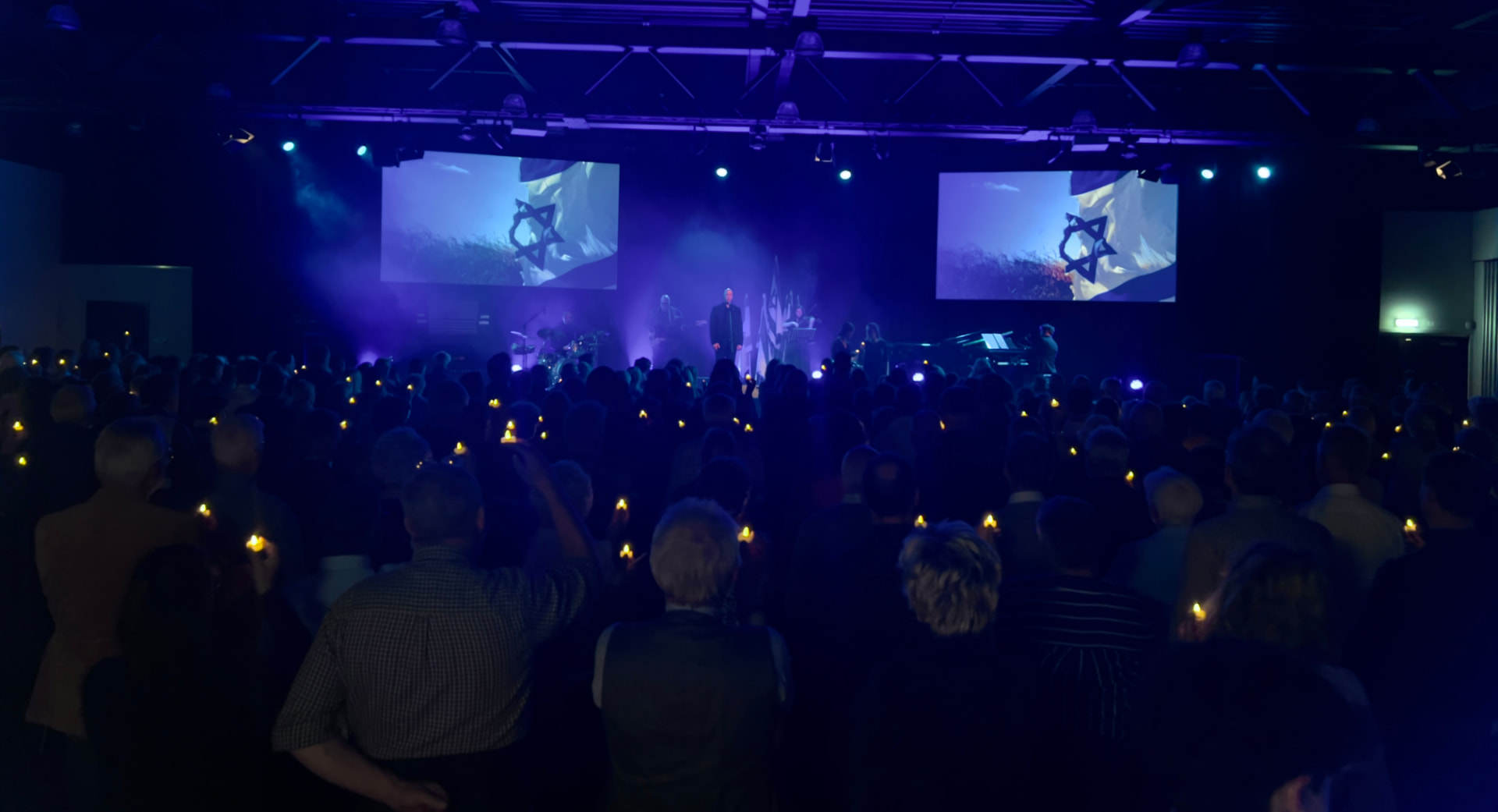 Intieme zaal met kaarsjes en beeldschermen