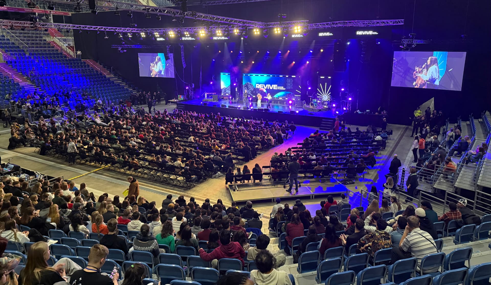 Grote indoor arena met REVIVE evenement en publiek